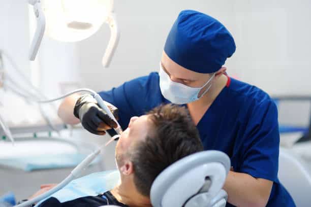 Patient receiving dental bridge treatment under bright overhead light
