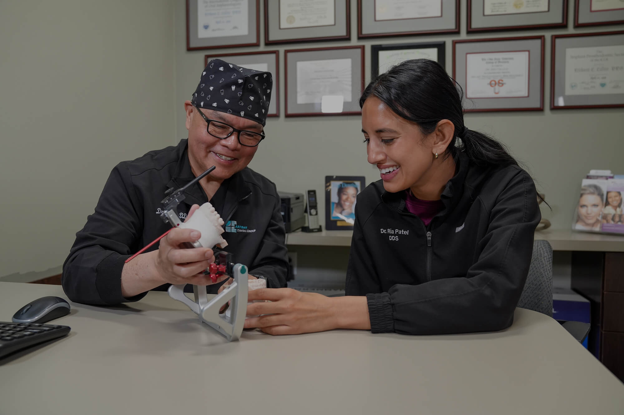 Artisan Dental Group dentists reviewing a dental implant model